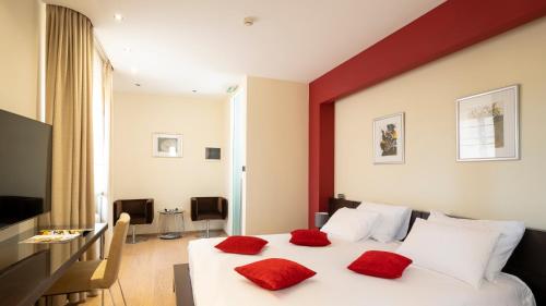 1 dormitorio con cama blanca y almohadas rojas en Restaurant Zigante Rooms, en Livade