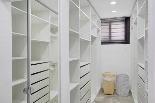 a walk in closet with white shelves and a window at Villa La Blanca in Arona