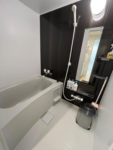 a bathroom with a white bath tub and a mirror at 福偉亭 in Otaru