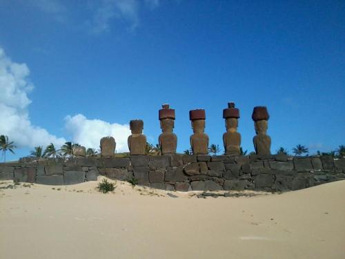 a group of mexican statues on a wall in the desert at PARAÍSO Sunset Bungalows in Hanga Roa