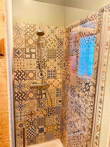 La salle de bains est pourvue d'une douche et d'un mur carrelé. dans l'établissement Jolie maison à la campagne « Chez Germaine », à Digosville