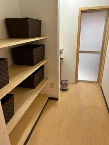 a room with a hallway with wooden shelves and a door at Guest House Koriyama in Koriyama