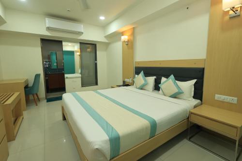 a bedroom with a large bed in a room at SN Blu Hotel in Ahmedabad