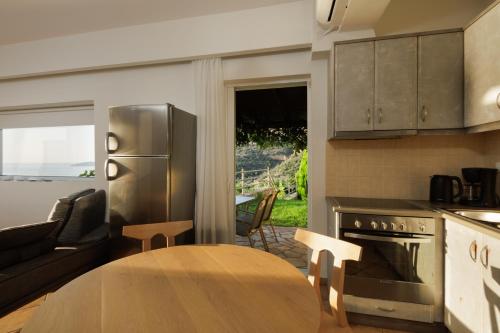 a kitchen with a table and a stainless steel refrigerator at Blue Horizon Suites in Paralion astros