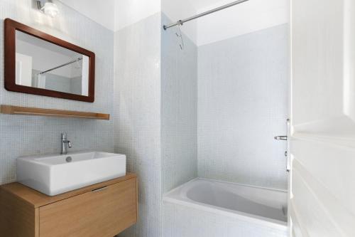 een badkamer met een wastafel en een bad bij Les Terrasses de Cogolin in Cogolin
