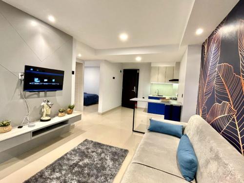 uma sala de estar com um sofá e uma cozinha em Alhesa Apartment em Sunggal