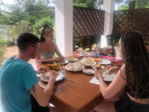 a group of people sitting around a table eating food at Senanayaka Holiday Inn in Polonnaruwa