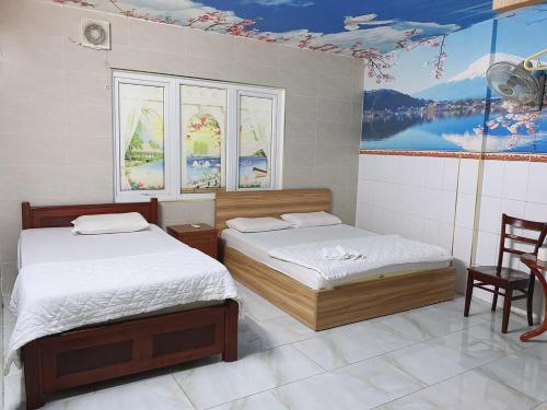 a bedroom with two beds and a painting on the wall at Thanh Thảo Hotel - 57/4 Lê Quang Qịnh, Q. Bình Thạnh - by Bay Luxury in Ho Chi Minh City