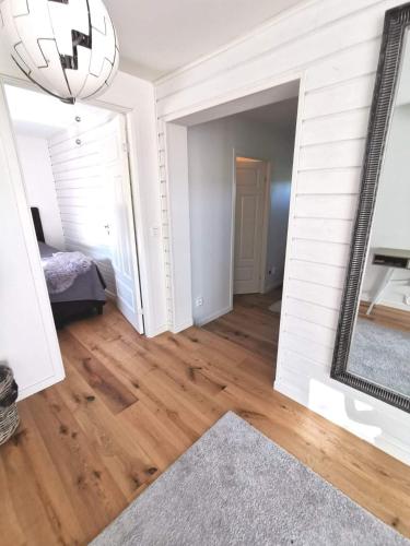 a living room with a mirror and a hard wood floor at Årsta strand in Stockholm