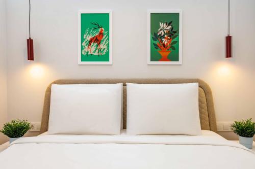 a bedroom with two white pillows and three paintings on the wall at Monnas Suite in Istanbul