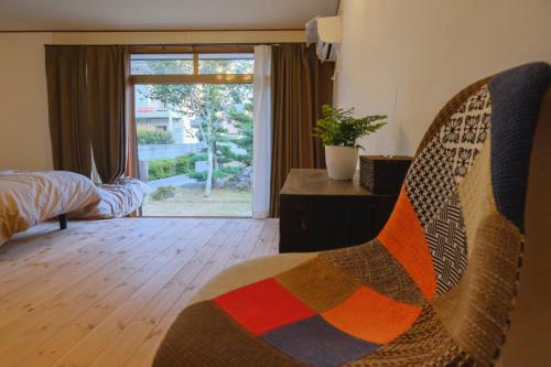 a living room with a chair and a window at Kominkahu kashikiri cottage Tokei - Vacation STAY 57497v in Nagano
