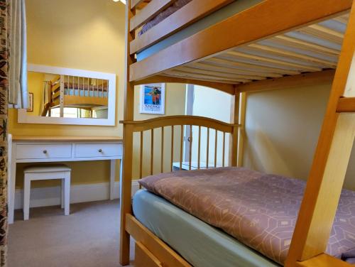 ein Schlafzimmer mit einem Etagenbett, einem Schreibtisch und einem Spiegel in der Unterkunft Rowden Mill Station in Bromyard
