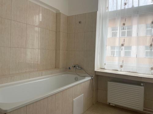 a bathroom with a bath tub and a window at Complex garsoniere. Studio Rentals in Onești