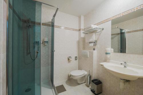 a bathroom with a shower and a toilet and a sink at Vila Horec - depandance hotela Hubert Vital Resort in Svätý Jur