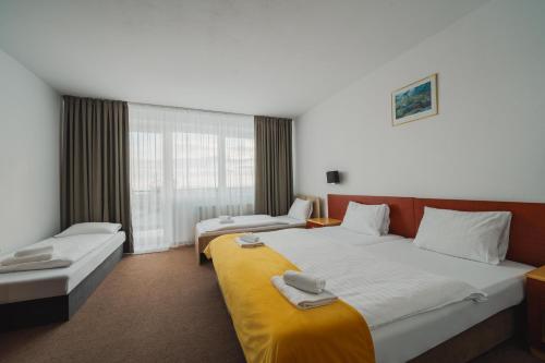 Cette chambre comprend 2 lits et une fenêtre. dans l'établissement Vila Horec - depandance hotela Hubert Vital Resort, à Gerlachov