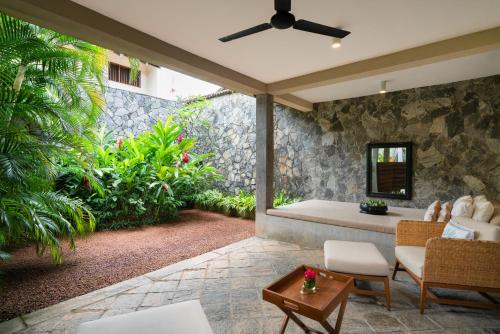 an outdoor patio with a couch and a table at Taru Villas The Long House - Bentota in Bentota
