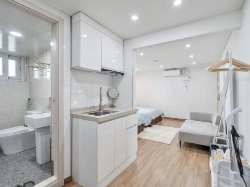 a white bathroom with a sink and a toilet at Harmony Stay in Seoul