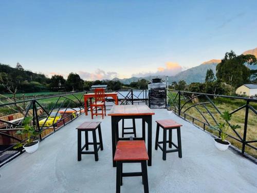 a group of tables and stools on top of a roof at Dimas Villa in Kintamani