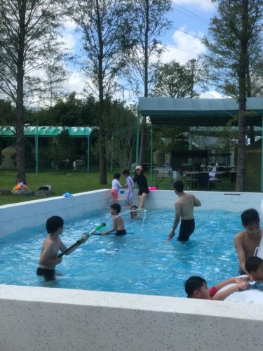 um grupo de pessoas brincando em uma piscina em Bald Cypress B&B em Lung-mu-ching