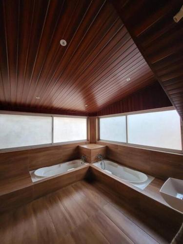 een grote kamer met 2 wastafels en een groot raam bij THE PERFECT STAYS : TRANQUIL VILLA in Lonavala