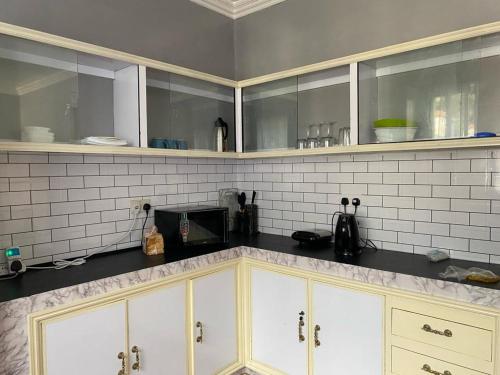 a kitchen with white cabinets and a counter top at Barzoo Homes in Kisumu