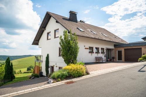 a white house with a driveway at Am Pön - Ferienwohnungen in Medebach