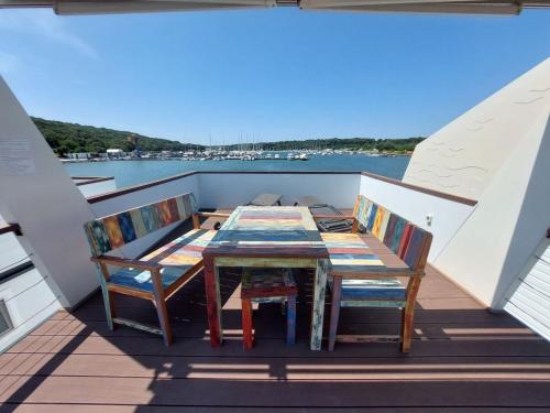 a table and chairs on the deck of a boat at HOUSE BOAT OLIVA - Floating House in Pula