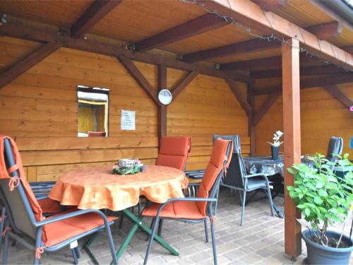 eine Terrasse mit einem Tisch und Stühlen in einem Gebäude in der Unterkunft Cosy and comfortable holiday home in the Harz region in Thale