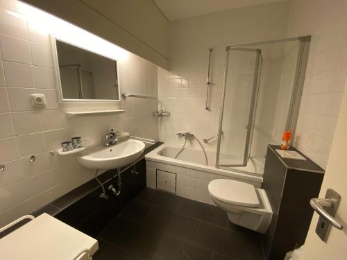 ein Bad mit einem Waschbecken, einem WC und einer Dusche in der Unterkunft Ferienwohnung von Damm in Bad Harzburg