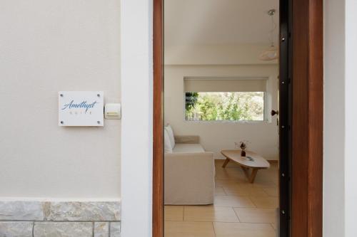 a door to a living room with a table and a chair at Blue Horizon Suites in Paralion astros