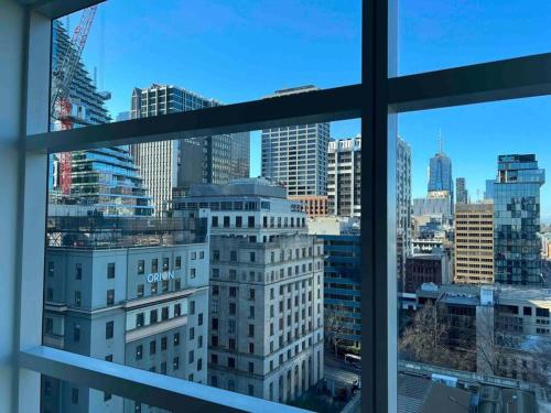 een raam met uitzicht op de skyline van de stad bij Exclusive Suite CBD Riverviews - ParkingOnsite in Melbourne