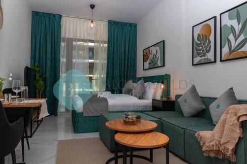 a living room with a green couch and a bed at Grandeur Studio In Oasis in Al Qurayyah