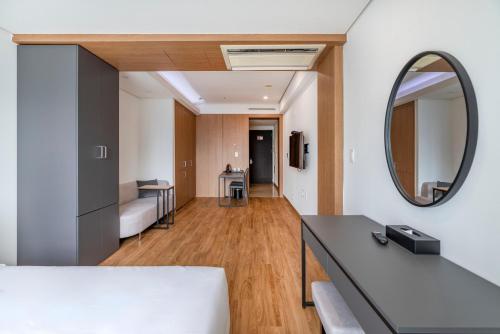 a living room with a bed and a mirror at Centum Convention Hotel In Centum in Busan