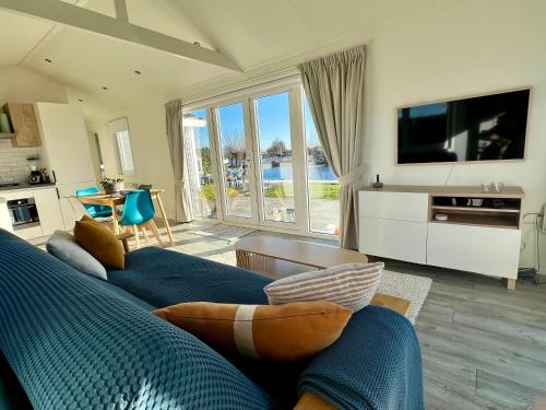 a living room with a blue couch and a tv at New - Waterfont Villa08 - Private Residence on a lake near Amsterdam in Vinkeveen