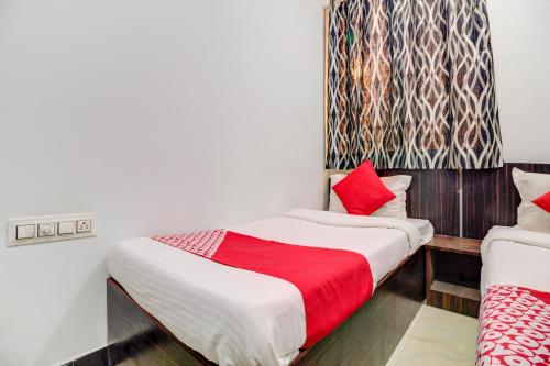 a bedroom with a bed with a red blanket at Anjali Hotel Jb Nagar Andheri in Mumbai