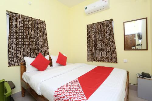 um quarto com uma cama com almofadas vermelhas e brancas em Flagship Nandan Residency em Bārang