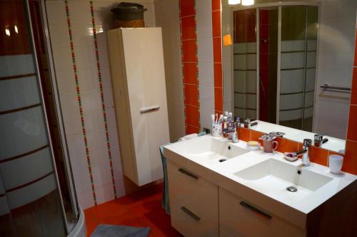 W łazience znajduje się biała umywalka i lustro. w obiekcie appartement dans villa aquarelle w mieście Biguglia