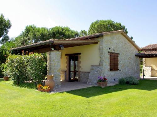 una pequeña casa de piedra con porche y patio en Inviting cottage in Marsciano with private terrace, en Marsciano