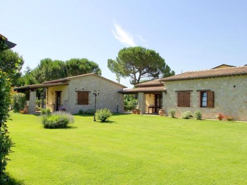 une maison avec une pelouse verte devant elle dans l'établissement Inviting cottage in Marsciano with private terrace, à Marsciano
