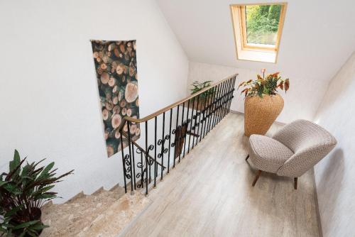 a stairway with a chair and a stair railing at Am Pön - Ferienwohnungen in Medebach