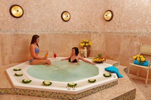 2 femmes assises dans un jacuzzi dans une baignoire dans l'établissement 358 Kaliva - Club Mykonos, à Langebaan