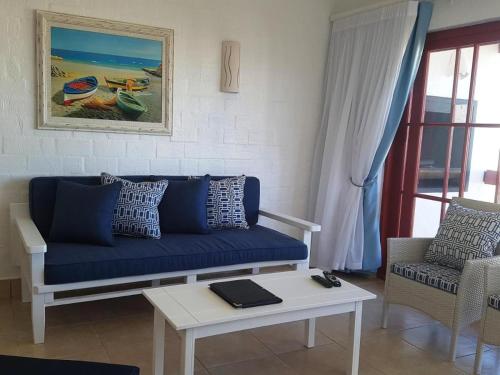 a living room with a blue couch and a table at 358 Kaliva - Club Mykonos in Langebaan