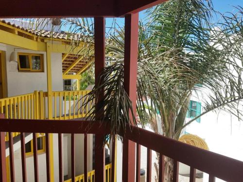 a house with a yellow fence and a palm tree at 358 Kaliva - Club Mykonos in Langebaan