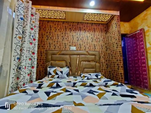 a bedroom with a large bed with a brick wall at Chapri homestay in Srinagar