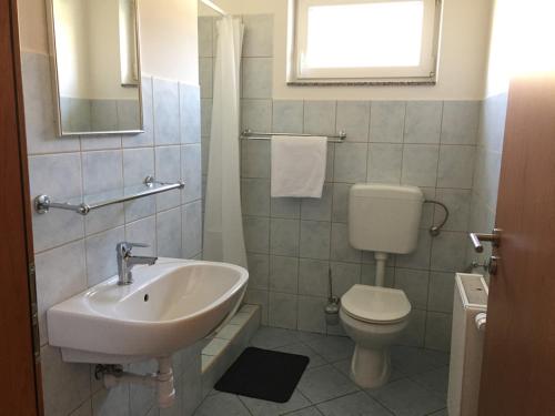 a bathroom with a sink and a toilet at Lamar Apartman in Kapuvár