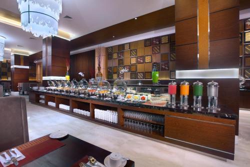 a bar with a long counter with many drinks at The Alana Hotel & Convention Center Solo by ASTON in Solo