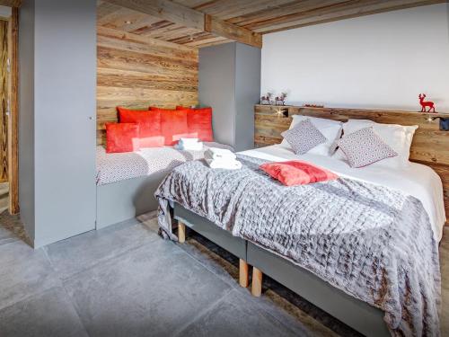 two beds in a bedroom with red accents at Chalet Alyssum - OVO Network in Le Grand-Bornand