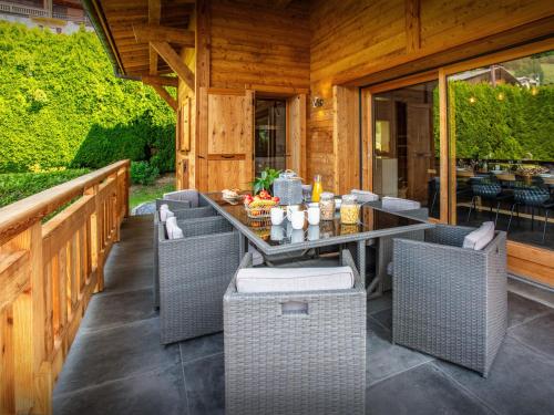 an outdoor patio with wicker chairs and a table at Chalet Alyssum - OVO Network in Le Grand-Bornand