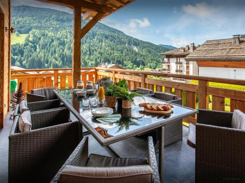 a table and chairs on a balcony with a view at Chalet Alyssum - OVO Network in Le Grand-Bornand