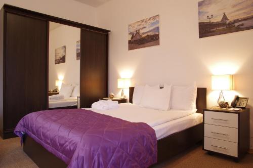 1 dormitorio con 1 cama grande con manta morada en Business Hotel IT Park, en Kazán